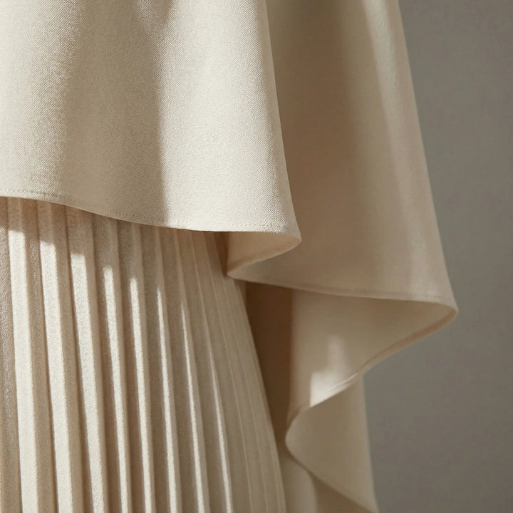 Maxi jurk met plissé rok en cape-overlay – elegant & vloeiend